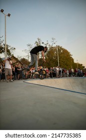 Kyiv, Ukraine - September 12, 2021: Extreme Cyclist Performs Tricks In The Skate Park. Extreme Sport. Crowded Skatepark. A Group Of Guys Show Tricks On The Ramp. BMX Tricks.