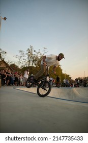 Kyiv, Ukraine - September 12, 2021: Extreme Cyclist Performs Tricks In The Skate Park. Extreme Sport. Crowded Skatepark. A Group Of Guys Show Tricks On The Ramp. BMX Tricks.