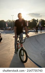 Kyiv, Ukraine - September 12, 2021: Extreme Cyclist Performs Tricks In The Skate Park. Extreme Sport. Crowded Skatepark. A Group Of Guys Show Tricks On The Ramp. BMX Tricks.