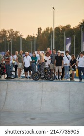 Kyiv, Ukraine - September 12, 2021: Extreme Cyclist Performs Tricks In The Skate Park. Extreme Sport. Crowded Skatepark. A Group Of Guys Show Tricks On The Ramp. BMX Tricks.