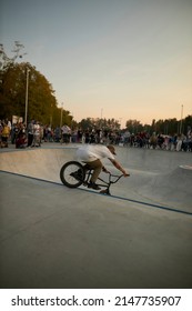 Kyiv, Ukraine - September 12, 2021: Extreme Cyclist Performs Tricks In The Skate Park. Extreme Sport. Crowded Skatepark. A Group Of Guys Show Tricks On The Ramp. BMX Tricks.