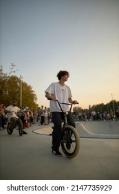 Kyiv, Ukraine - September 12, 2021: Extreme Cyclist Performs Tricks In The Skate Park. Extreme Sport. Crowded Skatepark. A Group Of Guys Show Tricks On The Ramp. BMX Tricks.