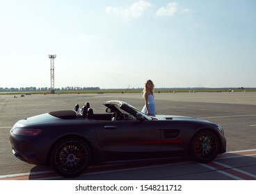 Kyiv, Ukraine - September 2, 2017: The elegant blonde beautiful woman posing near Mercedes Benz AMG GT 50 Edition sports car in airport. A new 2017 supercar designed to celebrate the 50th anniversary - Shutterstock ID 1548211712