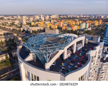 KYIV, UKRAINE - SEPTEMBER 2020: Group Of Adults Peoples Doing Yoga Outdoors On The Roof Of The High Building. Outdoor Group Yoga Classes Back View. Many People Do Yoga Exercises. Meditation And