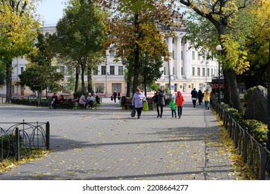 Kyiv, Ukraine - September 29 2022: People On Alleyway In Park Covered With Fallen Autumn Leaves