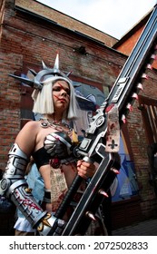 Kyiv, Ukraine - September 5, 2021: Young woman cosplaying Sister Repentia from Warhammer 40,000 miniature wargame holding eviscerator at Сomic Con Ukraine 2021