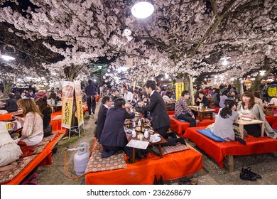 KYOTO, JAPAN - APRIL 3, 2014: Crowds enjoy the spring cherry blossoms by partaking in seasonal nighttime Hanami festivals in Maruyama Park. 