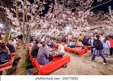 KYOTO, JAPAN - APRIL 3, 2014: Crowds enjoy the spring cherry blossoms by partaking in seasonal nighttime Hanami festivals in Maruyama Park. 