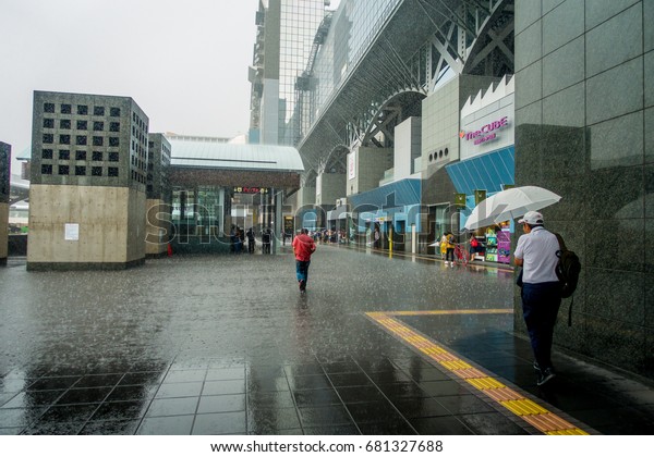 KYOTO, JAPAN - JULY 05, 2017: Unidentified people\
walking in the rain at the enter of Keihan Railway Station in\
Kyoto, Japan. Keihan Railway company was founded in 1949 and is\
among busiest in Japan