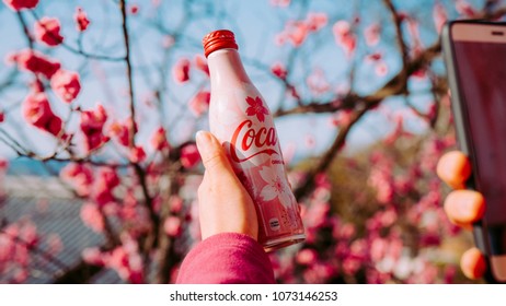 Kyoto, Japan - March 17, 2018: The Girls Holding A Sakura Coca-Cola,Coke Bottle With Cherry Blossoms Background On Spring