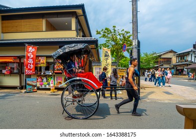 KYOTO, JAPAN, MAY 01, 2017: Tourists riding a rickshaw touring the streets of Arashiyama near the Togetsukyo Bridge.
