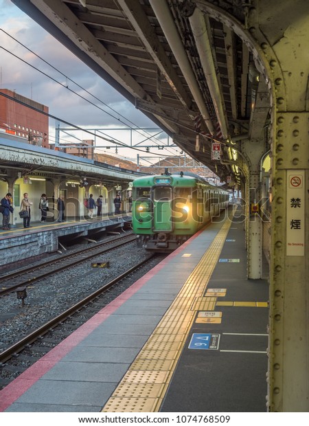 KYOTO, JAPAN - NOVEMBER 24 : Green car classic\
train from Kyoto station stops at Arashiyama train station in\
Kyoto, Japan, on November 24,\
2017.