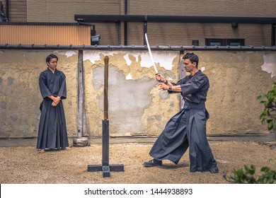 Kyoto - May 29, 2019: Western traveler practicing Iaido sword fighting in a Samurai Experience event in Kyoto, Japan