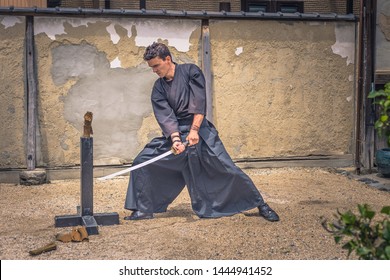 Kyoto - May 29, 2019: Western traveler practicing Iaido sword fighting in a Samurai Experience event in Kyoto, Japan