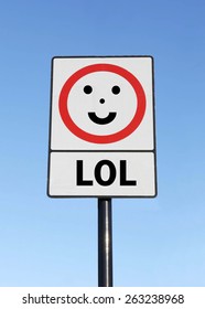 L O L (Laugh Out Loud) written on a smiling road sign against a clear blue sky background