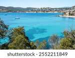 La Baumette beach, red rocks and peebles beach surrounded by trees, in Massif de l