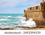 La Caleta Beach, Balneario de la Palma Building and Castle of San Sebastian at sunset - Cadiz, Andalusia, Spain