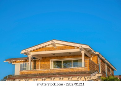 La Jolla, California- Balcony Of A House With Glass Railings. Second Floor Exterior Of A House With Wood Shingle Sidings And White Trims Against The Clear Blue Sky.
