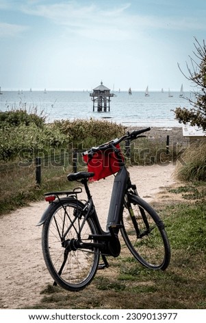 La Rochelle Minimes harbor. Rear view of an electric bicycle looking at at the End of the World or Le Phare du Bout du Monde standing on observation point. Stock fotó © 