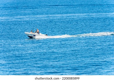 LA SPEZIA, ITALY - JULY 15, 2022: White Speedboat With Two Adults Fishermen On Board With Fishing Rods, In Motion In The Blue Mediterranean Sea, Gulf Of La Spezia, Liguria, Italy, Southern Europe.