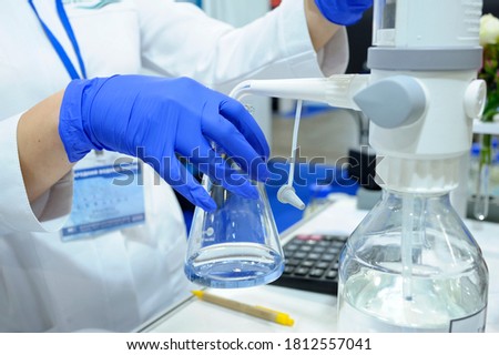 Lab assistant hands working with titrator to measure quality of water