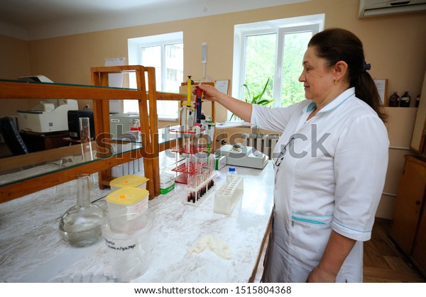Lab assistant\
standing in front of a work table with vacutainers with blood\
prepared for complete blood count. Lab of the municipal hospital.\
April 10, 2019. Kiev,\
Ukraine