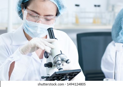 Lab assistant and veterinarian examining tissues sample under the microscope