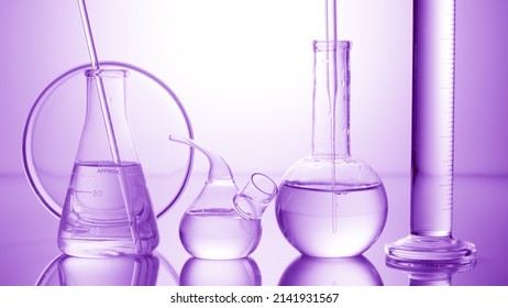 Lab glassware filled with transparent liquid on violet background | Abstract science concept