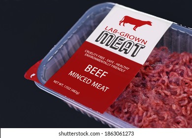 Lab grown cultured meat concept for artificial in vitro cell culture meat production with packed raw minced beef meat with made up label on dark background