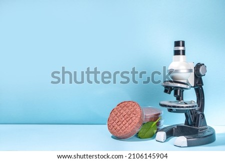 Lab grown meat alternatives concept, Various laboratory grown meat types red and white meat with microscope, laboratory accessories, measuring utensils 