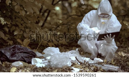 Lab researcher entering data report on tablet analyzing plastic garbage forest