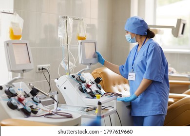 Lab Scientist Placing Test Tubes With Blood Samples In Centrifuge