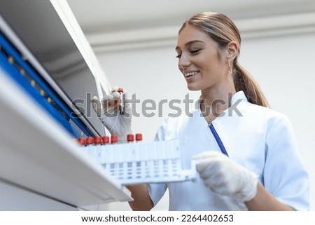 Lab tech loading samples into a chemistry analyzer. female lab tech loading specimen for coagulation test analysis