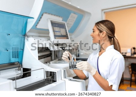 Lab tech loading samples into a chemistry analyzer. female lab tech loading specimen for coagulation test analysis