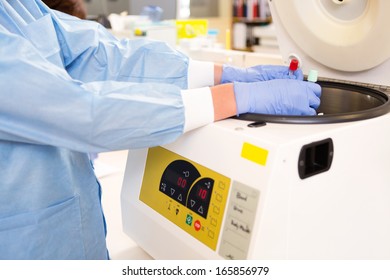 Lab Tech Loading Test Tubes In Centrifuge