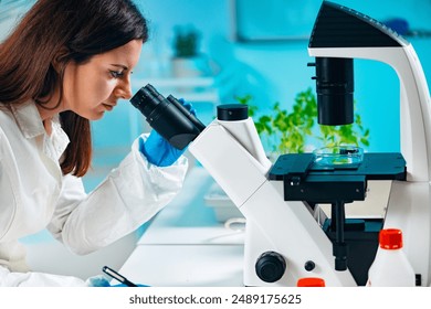 Lab Technician Examining plant tissue with microscope - Powered by Shutterstock