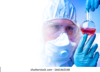 Lab Technician Holding A Test Tube In His Hands. Concept - Epidemiology. A Man Holds A Test Tube With A Dangerous Virus. Virus Study. Epidemiologist In A Protective Suit. Concept - Fever Study