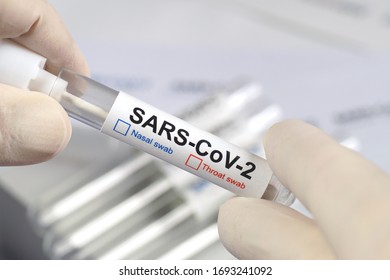 The Lab Technician Shows A Vial With A Nasal Or Throat Swab. COVID -19 (SARS CoV-2). Tests For The Presence Of Coronavirus In The Body. 