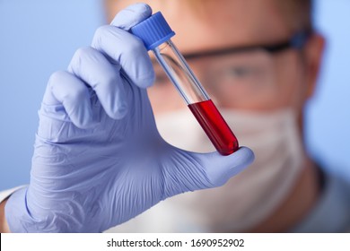 Lab. A Lab Technician In A White Coat, Rubber Gloves And Protective Glasses Checks The Behavior Of The Substance In A Closed Environment.