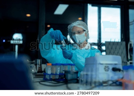 Lab work, scientists holds a test tube takes the test from a test tube in analysis for vaccine development.