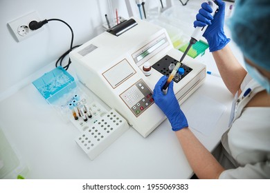 Lab Worker Conducting A Coagulation Test Using An Automated Pipette