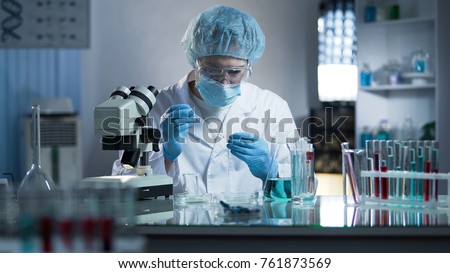 Lab worker dripping sample onto laboratory glass to research cloning process