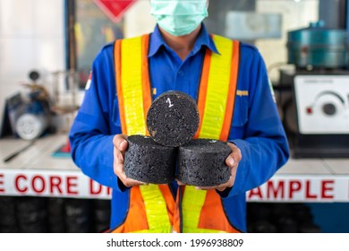 
a lab worker is holding bits of asphalt for quality testing in the laboratory.May 12 2017 West Java-Indonesia.