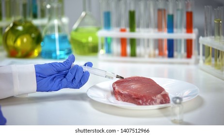 Lab worker injecting medication into meat sample, african swine flu analysis