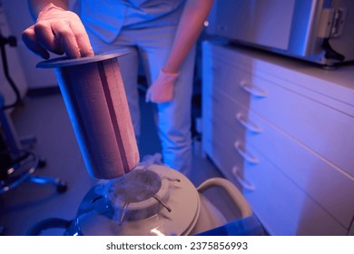 Lab worker using cryogenic container for preservation of biological material