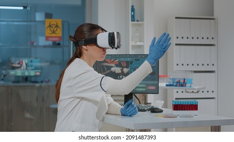 Lab Worker Using Vr Goggles With 3d Projection In Science Laboratory. Woman Scientist Working With Virtual Reality Headset To Develop Biochemistry Simulation For Analysis. Futuristic Innovation