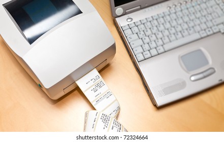 Label and barcode printer next to a notebook