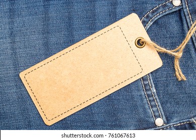 Label Price Tag Mockup On Blue Jeans From Recycled Paper.