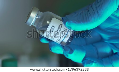 label translation: Sputnik 5, COVID-19 vaccine, 10ml per dose
Gloved hand of a doctor holding a vial of Russian covid-19 vaccine or sputnik v