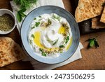 Labneh yogurt cream cheese with olive oil, herbs and zaatar close up. Traditional arabian or middle eastern homemade labneh dip with pita bread. Greek yogurt. Arabic Cuisine.